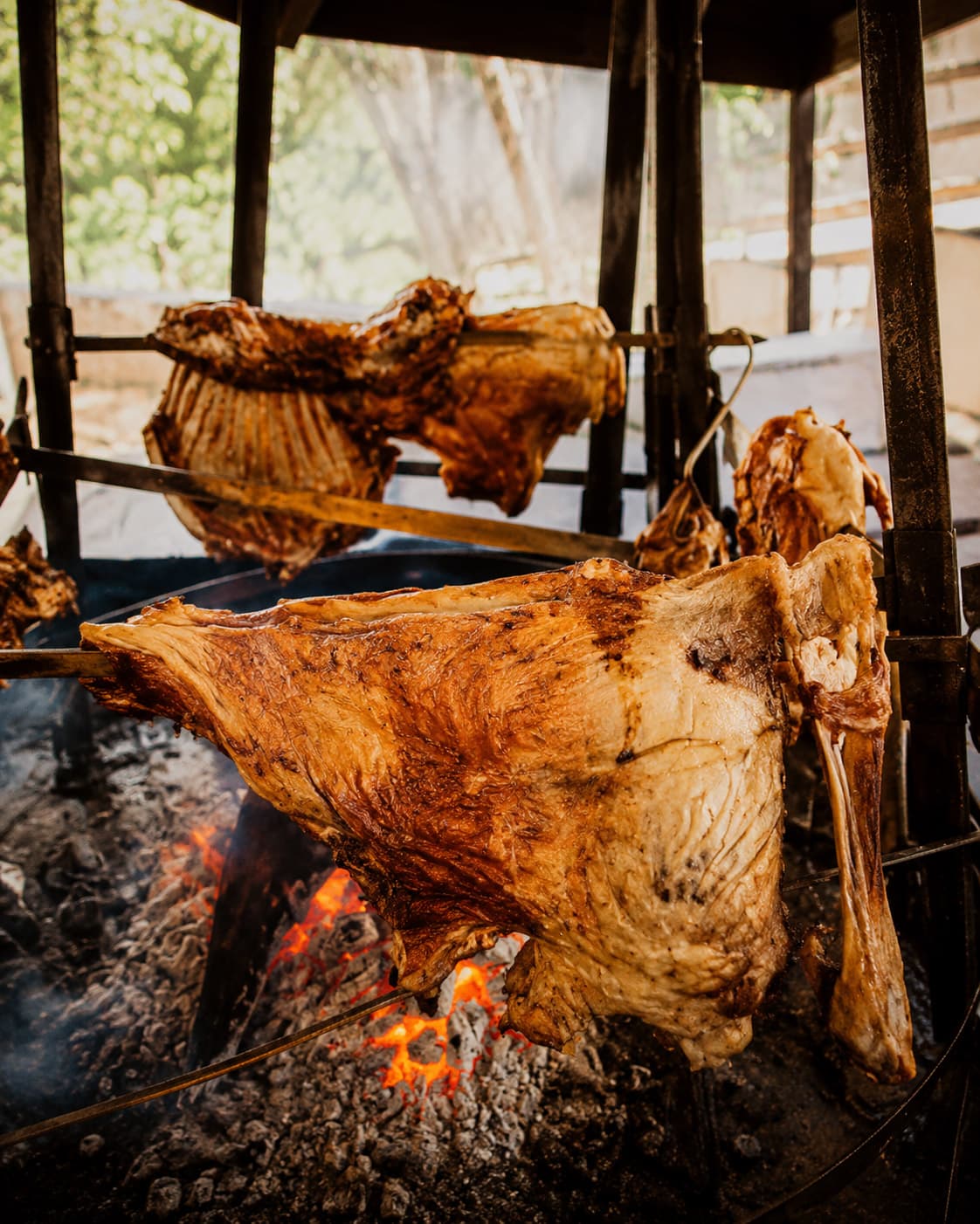 Traditional Cretan antikristo lamb roasting upright around an open fire